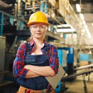 Portrait of young woman in protective glasses in the factory